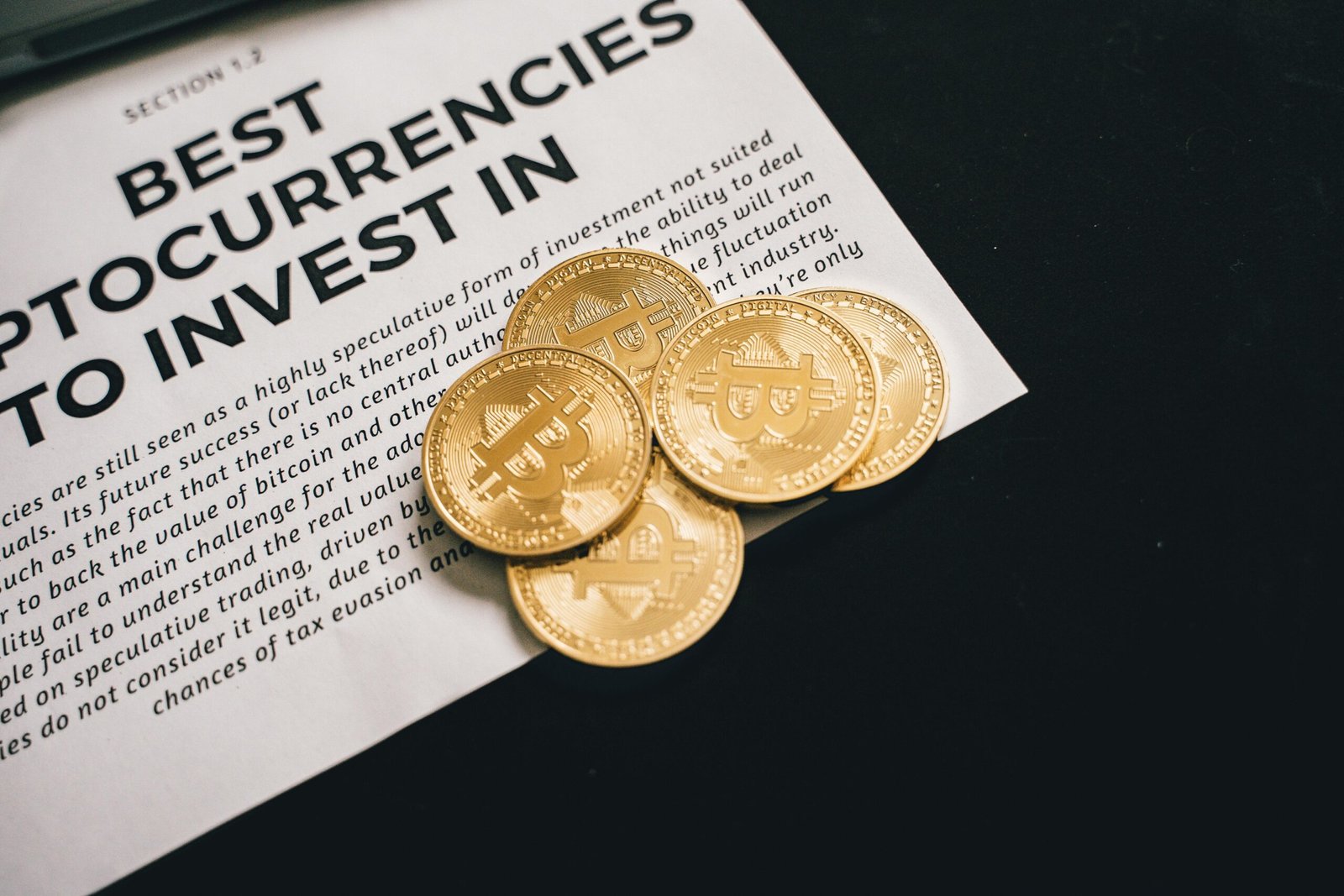 Close-up of Bitcoin coins on investment document promoting cryptocurrencies.